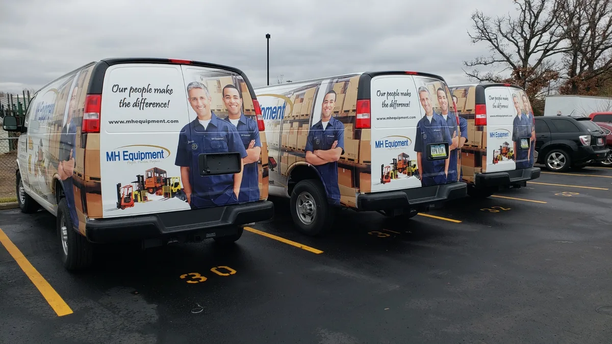 MH Equipment wrapped cargo vans parked in a row